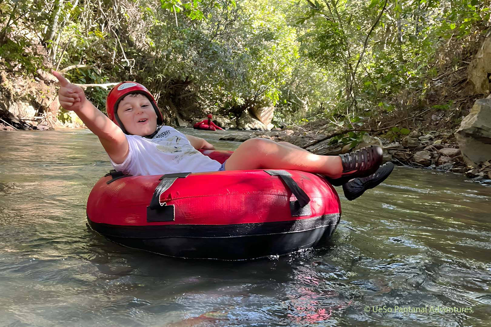 Garçon sur une bouée dans la rivière de la forêt